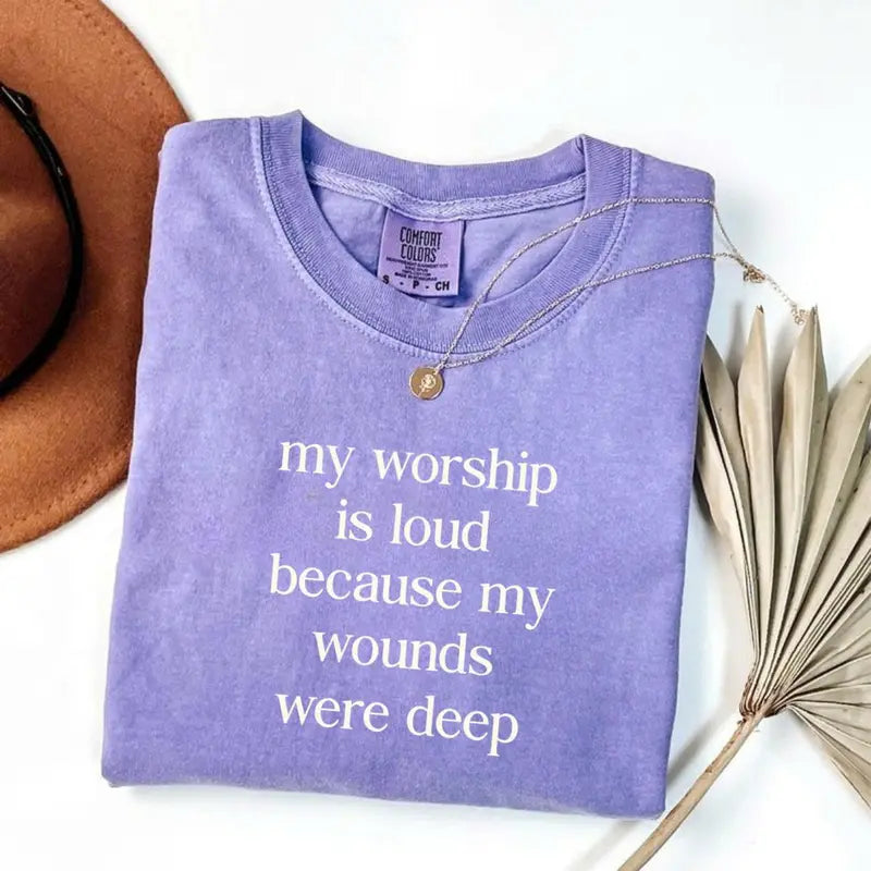 Violet short-sleeve T-shirt with V-neck and gold necklace; front word graphic