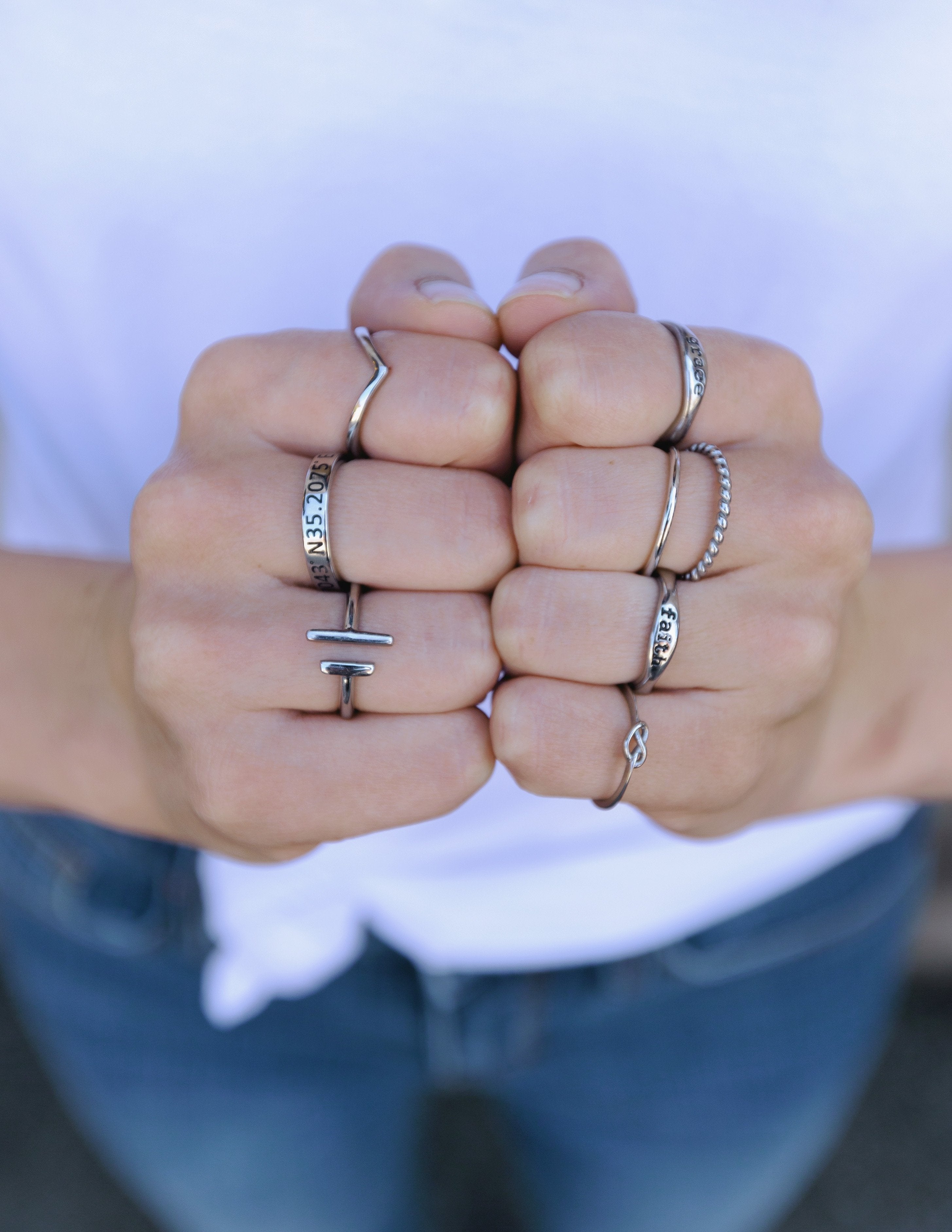 Silver double bar ring on a finger, featuring two vertical bars on the band