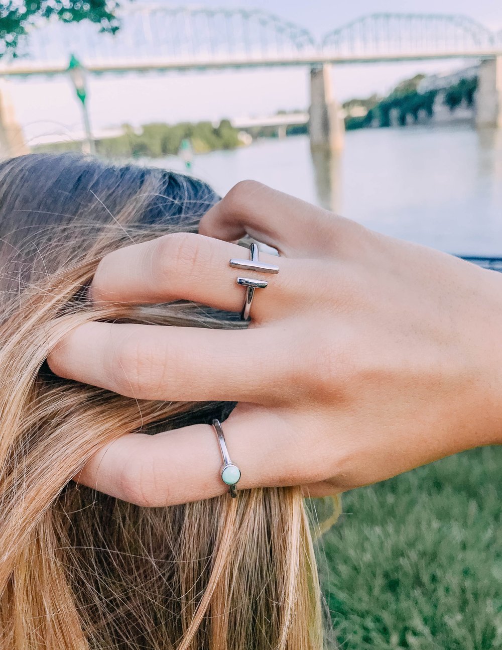 Silver double bar ring on finger, with the band and two vertical bars visible