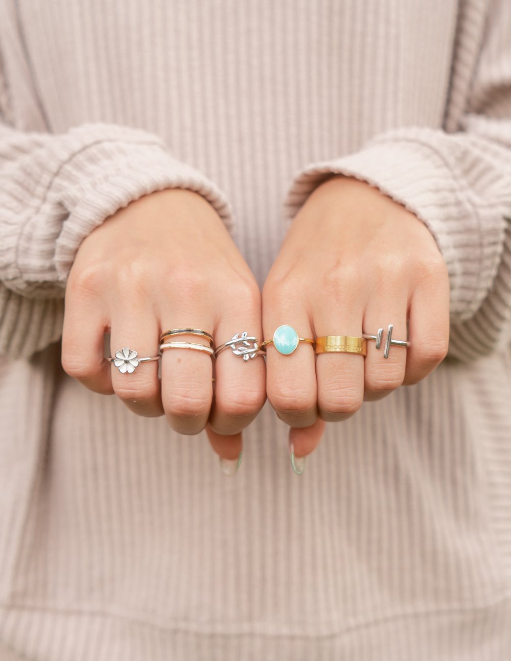 Silver double bar ring on a finger, shown among multiple stacked rings