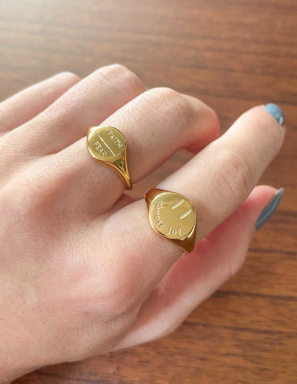 Gold-tone heart rings on fingers, engraved text on top and slender open bands