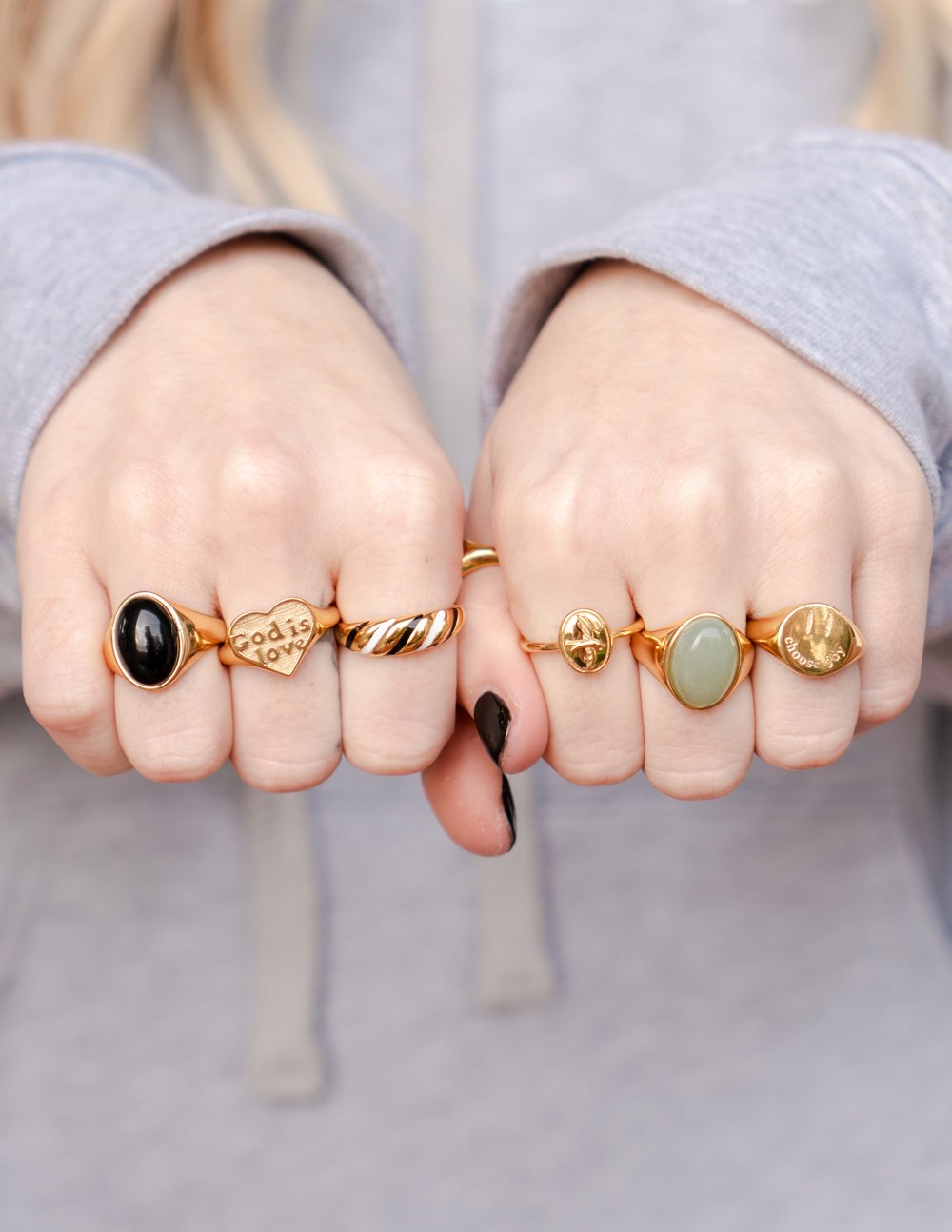 Gold-tone ring with black oval gemstone and small engraved text on band