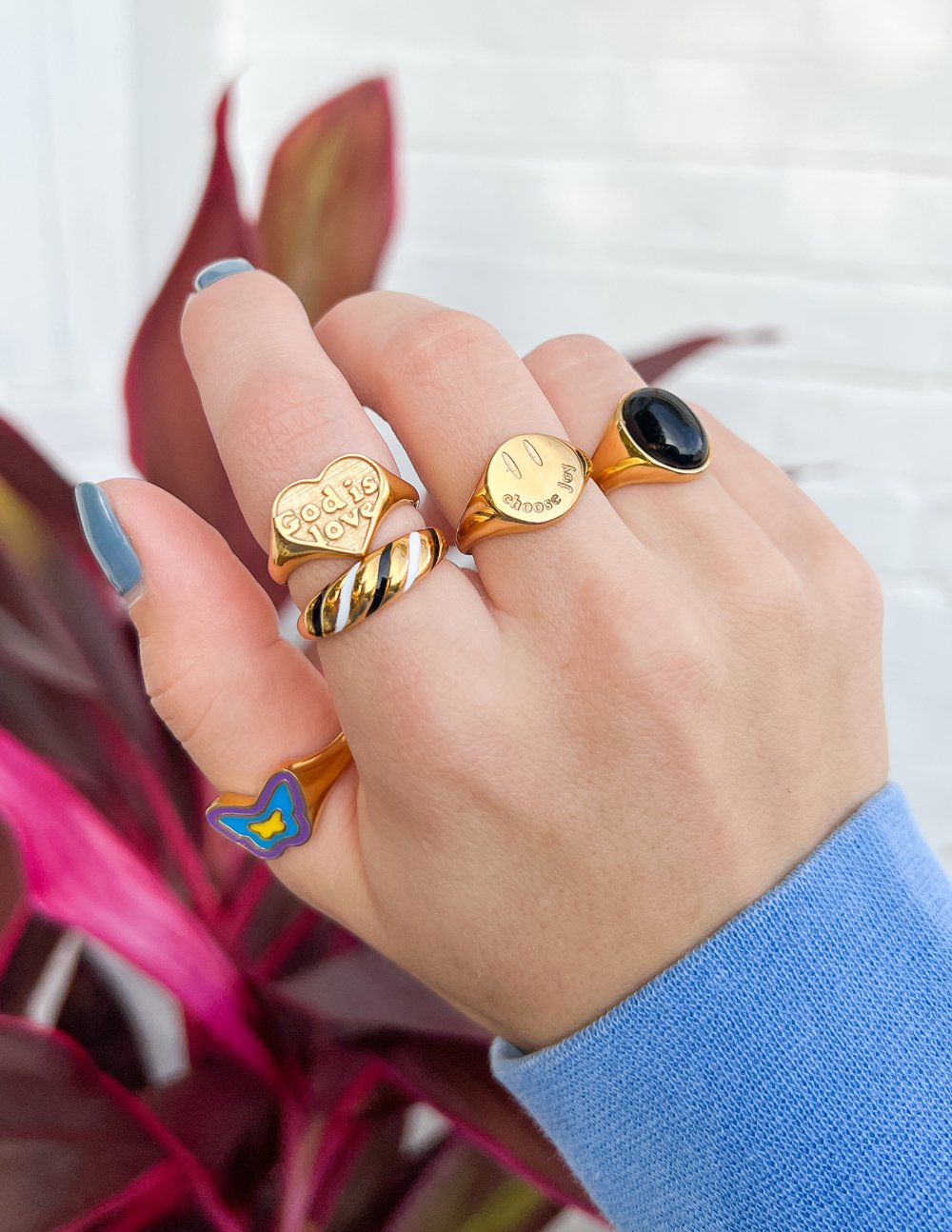 Gold-tone signet ring with black oval stone and engraved face on top