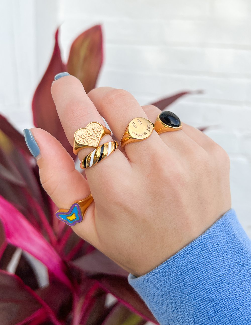 Gold heart-shaped 'Choose Joy' ring on hand