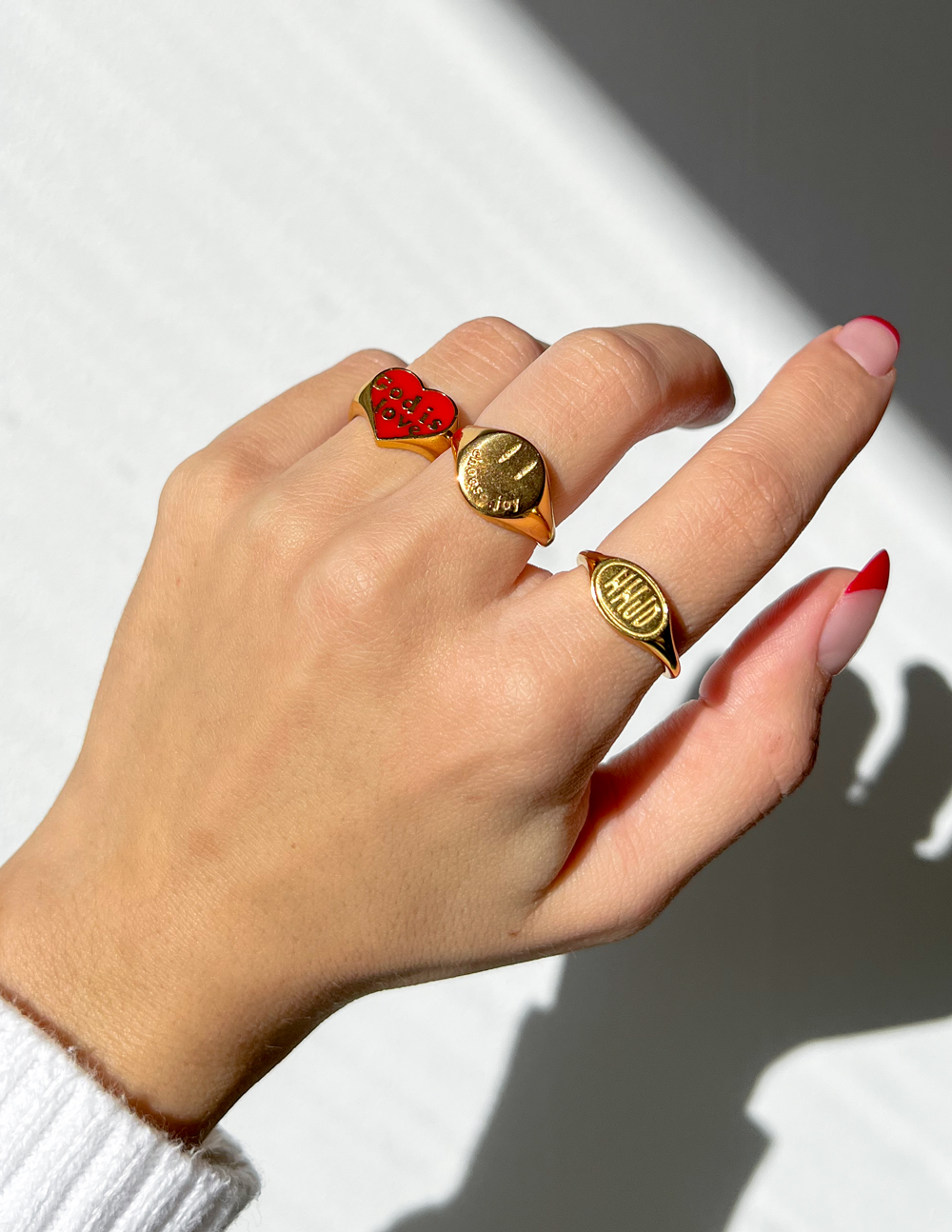 Gold heart-shaped 'Choose Joy' ring on finger