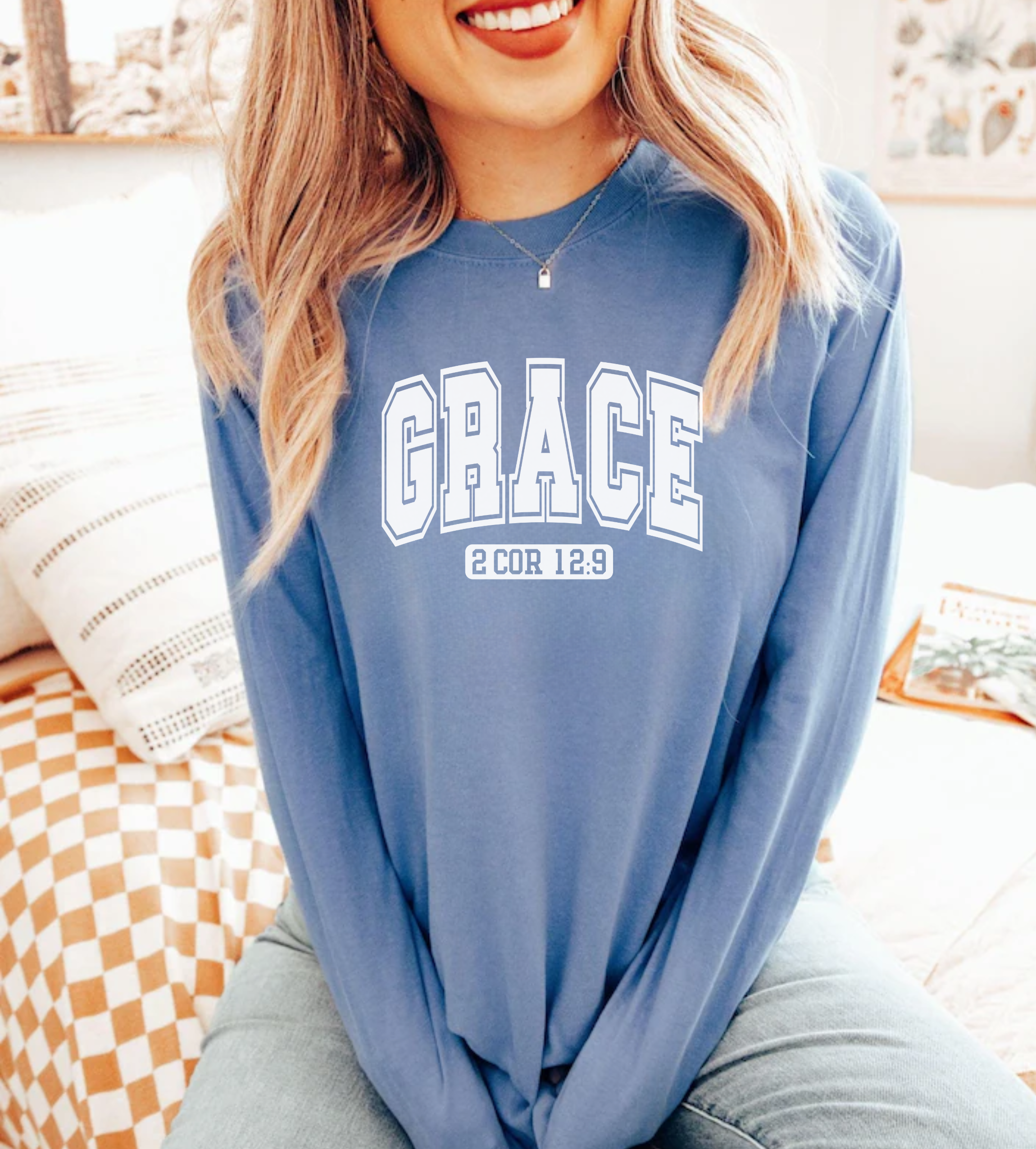 Blue long-sleeve crewneck tee with 'GRACE' front graphic and 2 Cor 1:9 print