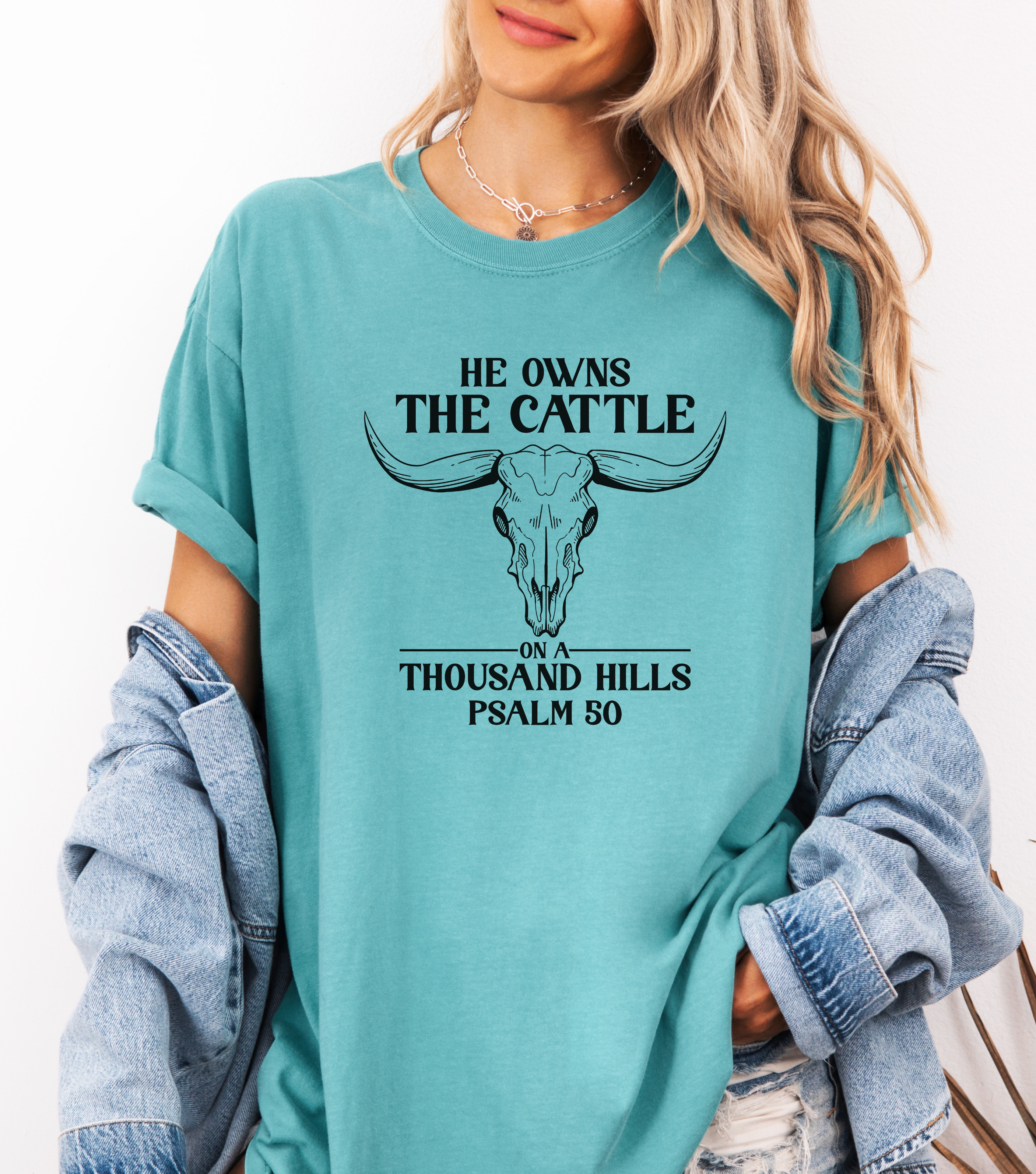 Teal graphic cattle tee with bull head and 'He owns the cattle' slogan