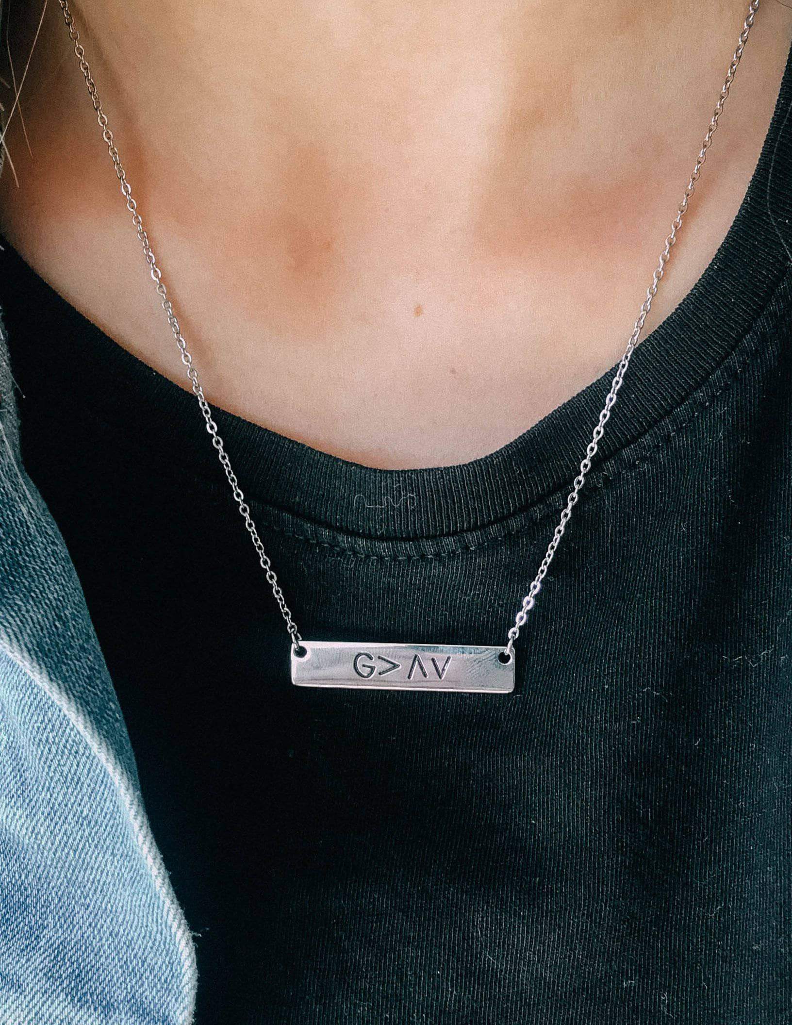Silver chain pendant necklace with rectangular G>AV bar on black top