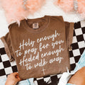 Brown graphic T-shirt with white cursive quote text: 'holy enough' 'walk away'