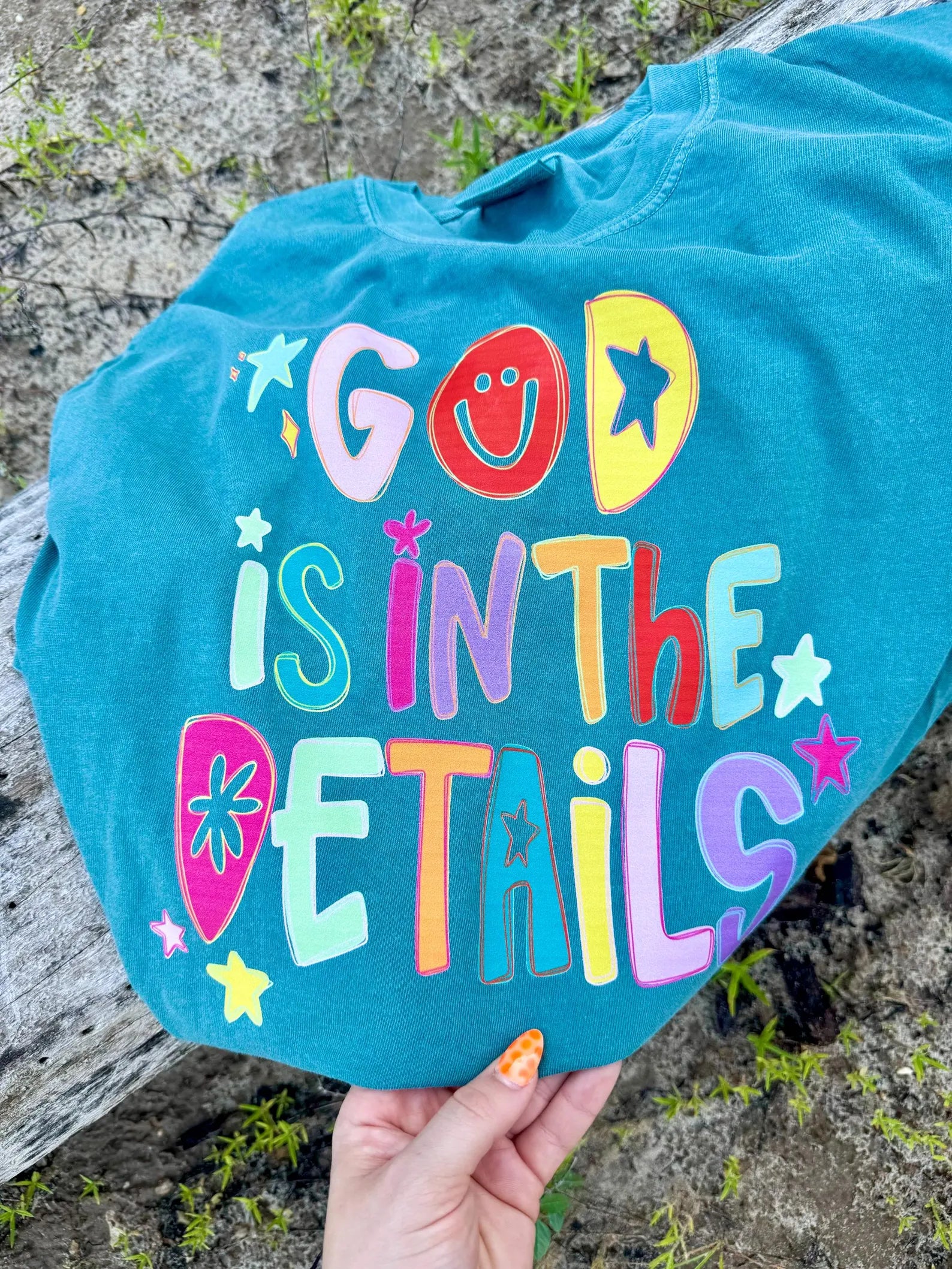 Turquoise sweatshirt with colorful "God Is In The Details" lettering