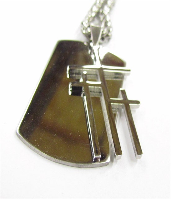 Gold-tone dog tag pendant with triple cross cutouts on a chain