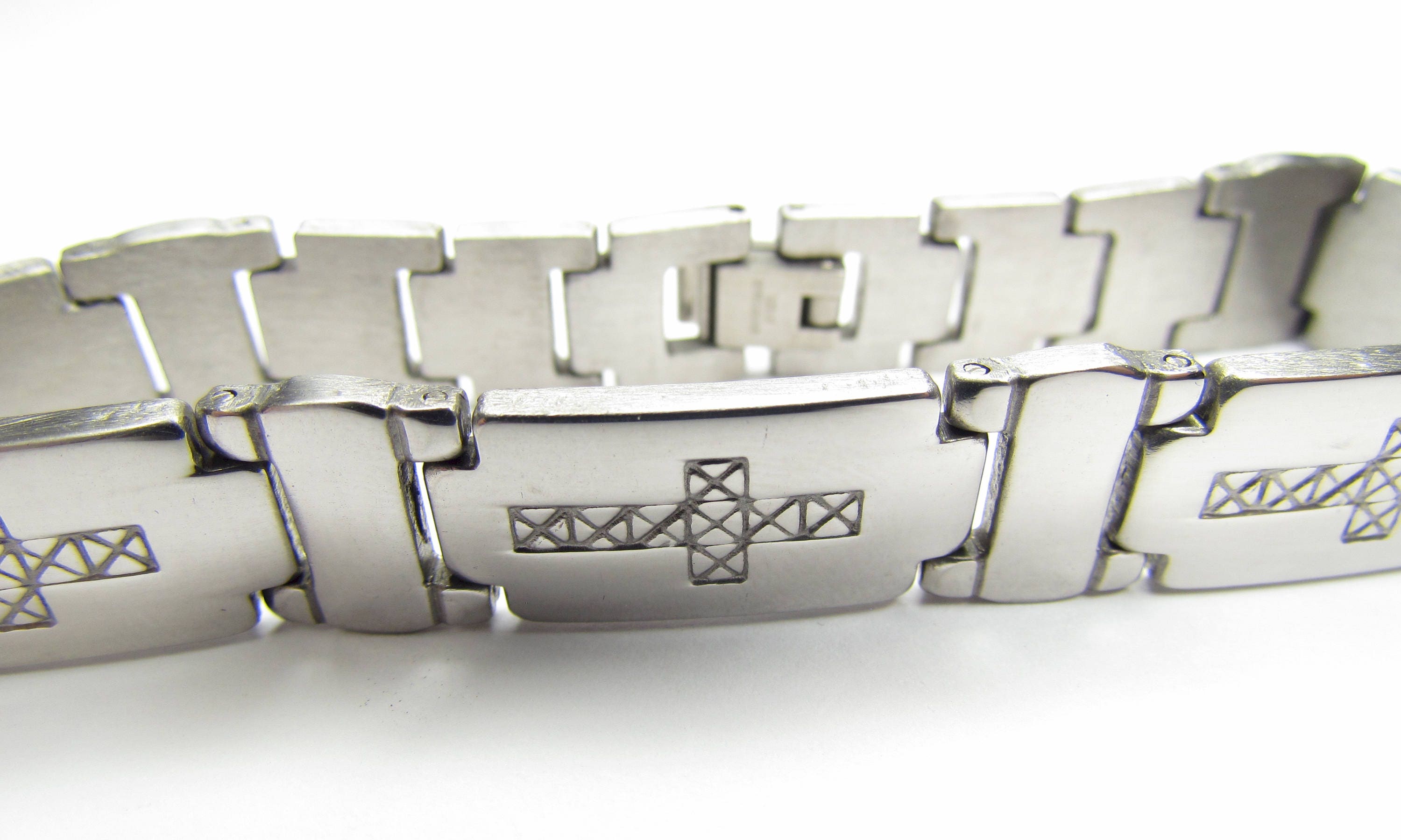 Stainless steel cross bracelet angled view with engraved horizontal cross and link edges