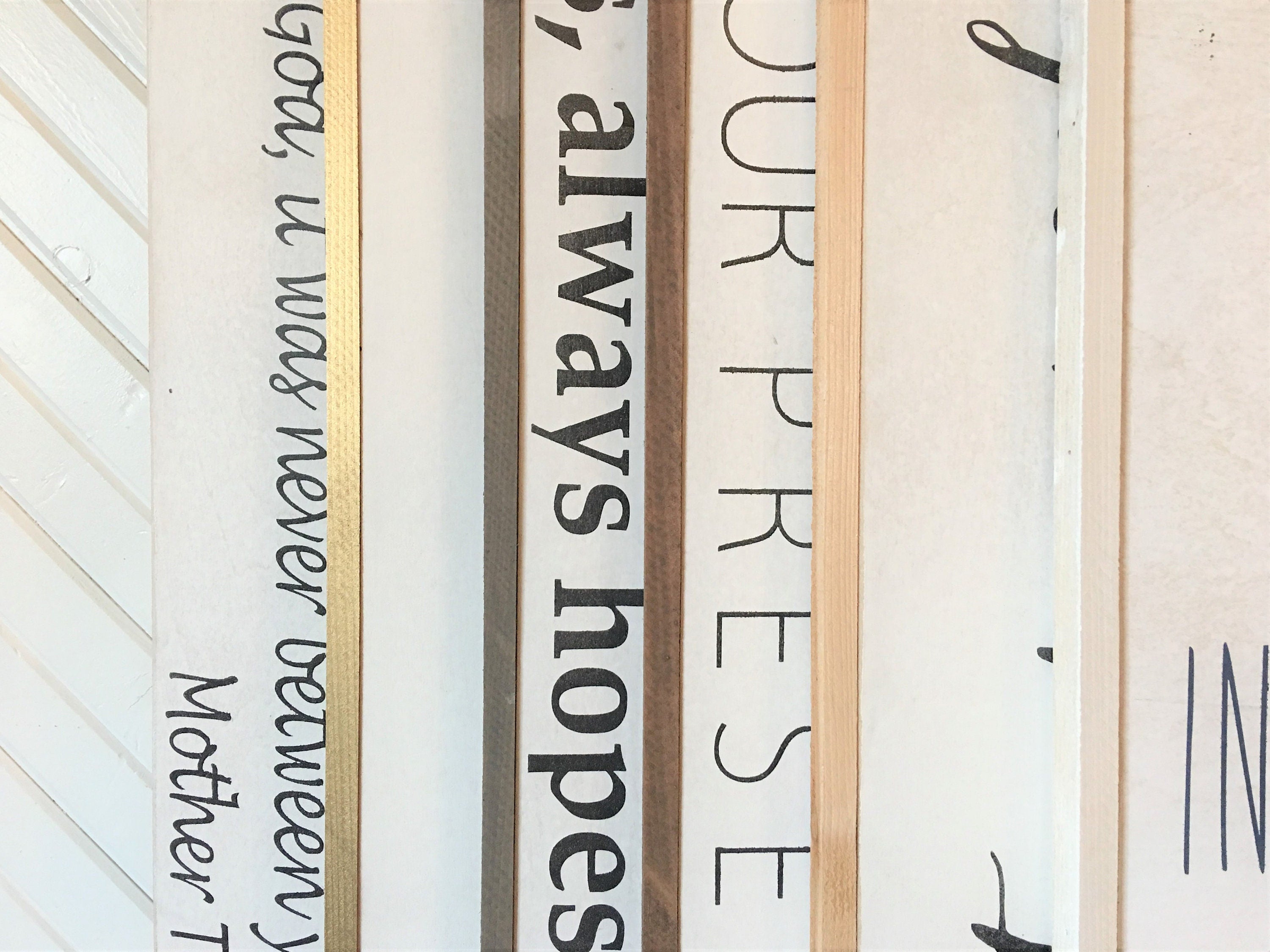 Wood framed wall sign close-up with partial scripture text in dark ink