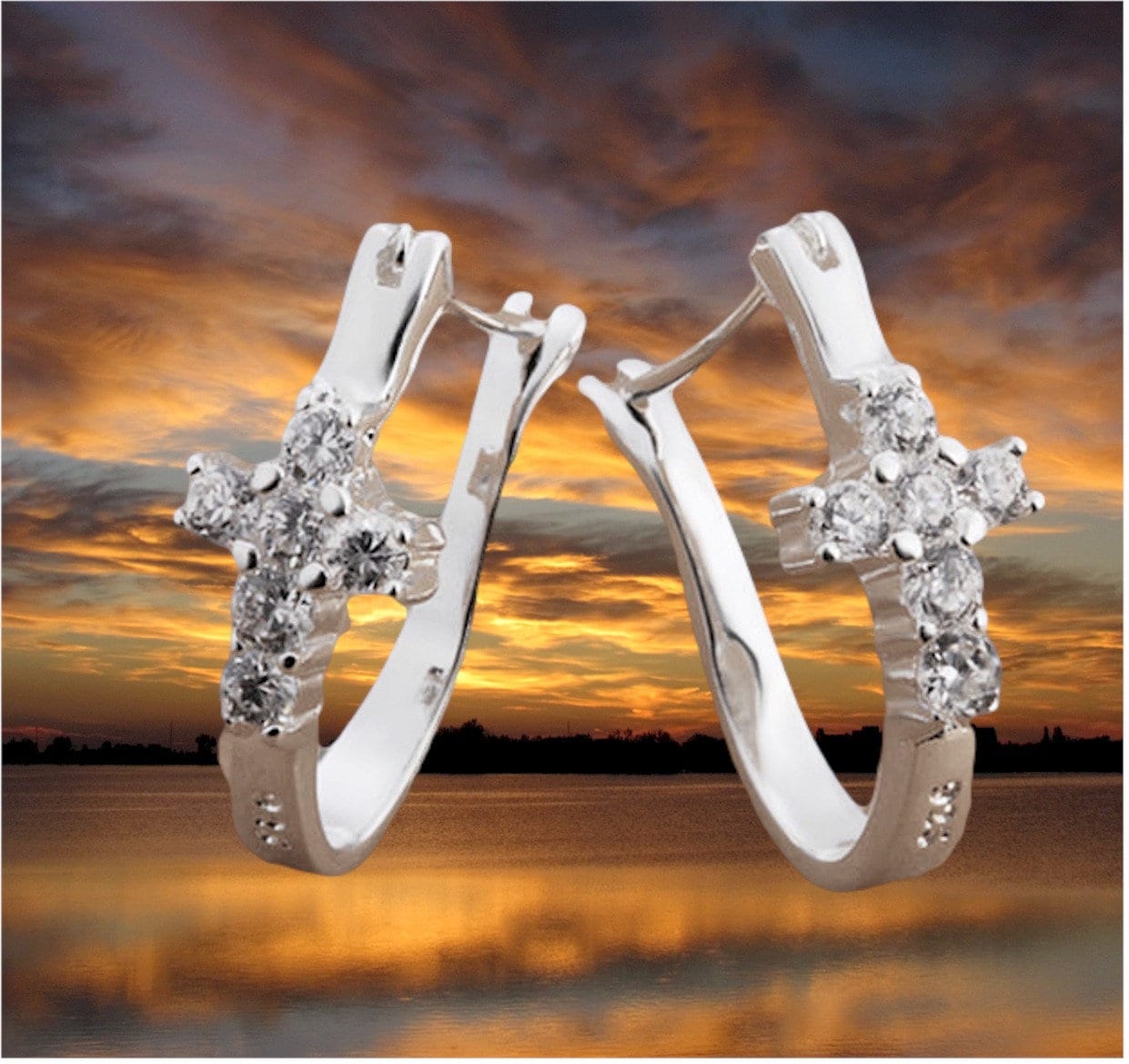 Silver-tone huggie hoop earrings with cross-shaped clear CZ cluster details.