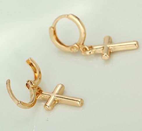 Gold-tone cross dangle hoop earring with lever closure, close-up