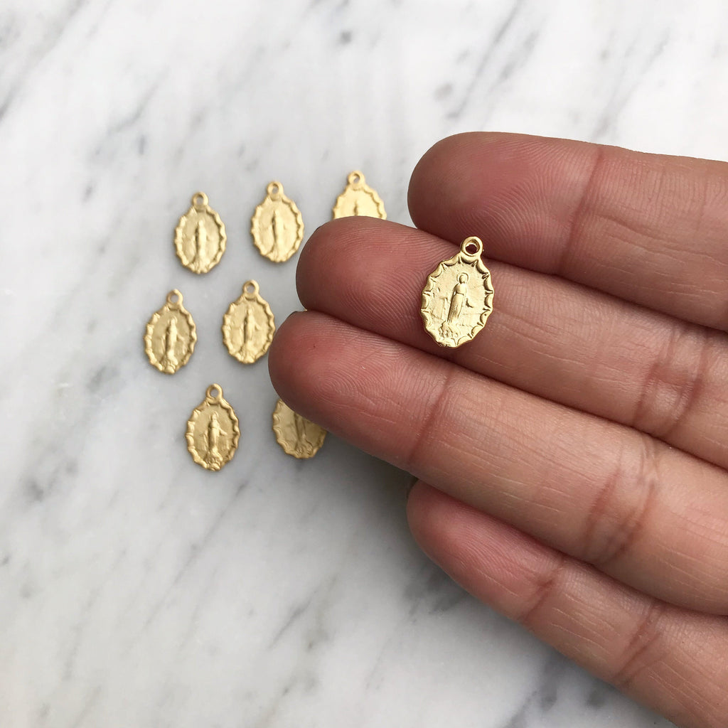 Set of gold-tone medal charms with loops, displayed on a flat surface