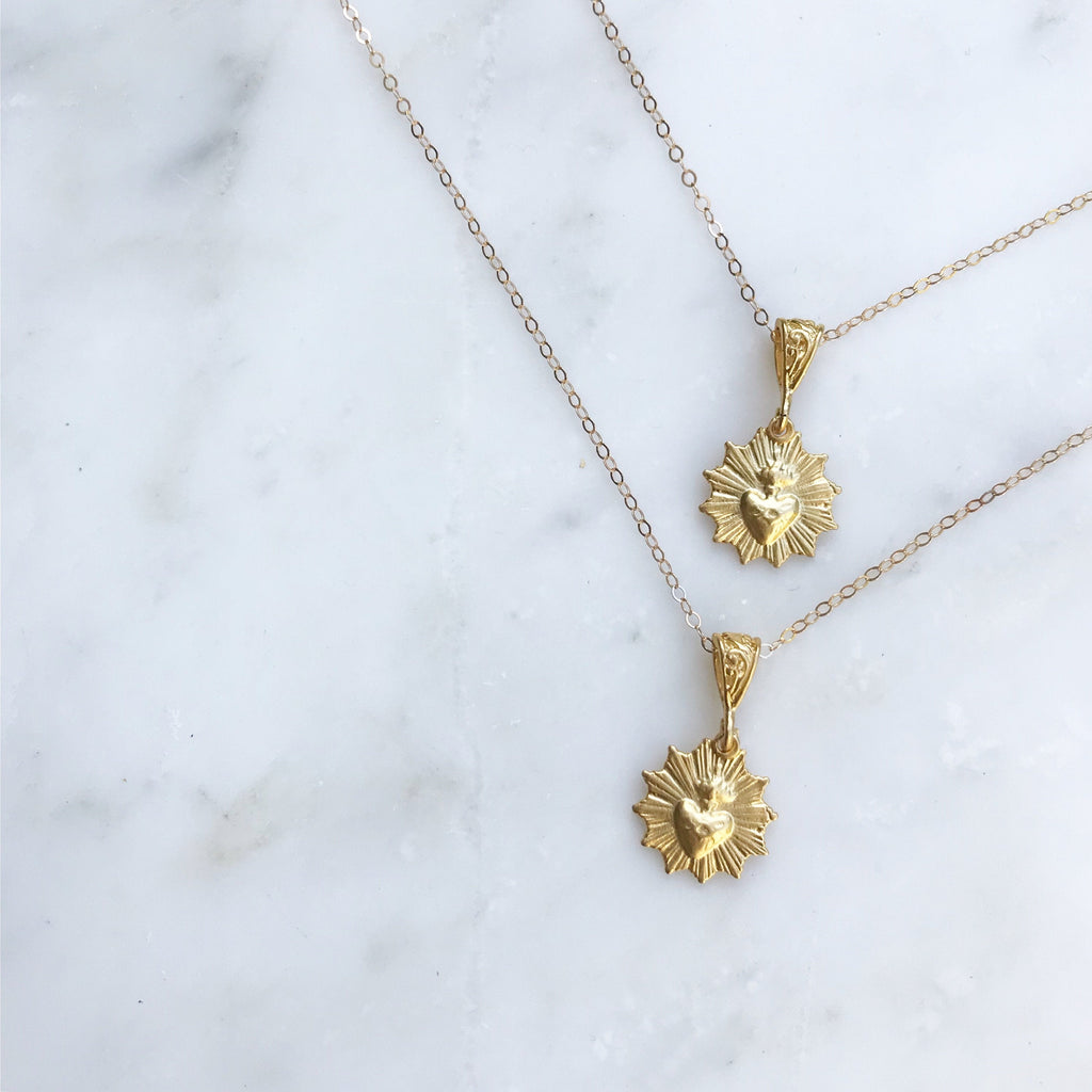 Gold-tone scalloped heart charm necklace with two dangling medallions