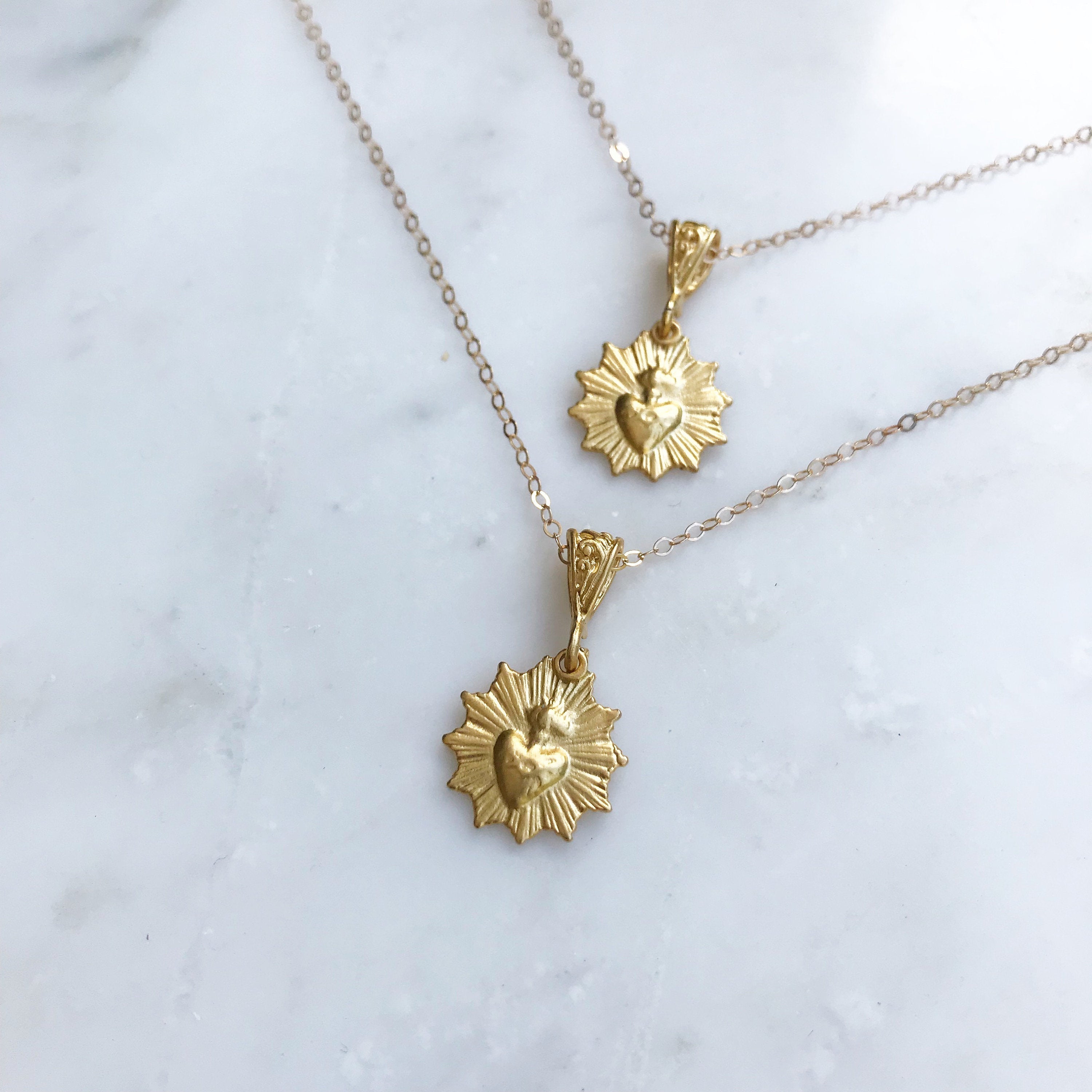 Gold-tone scalloped heart charm necklace with two dangling medallions