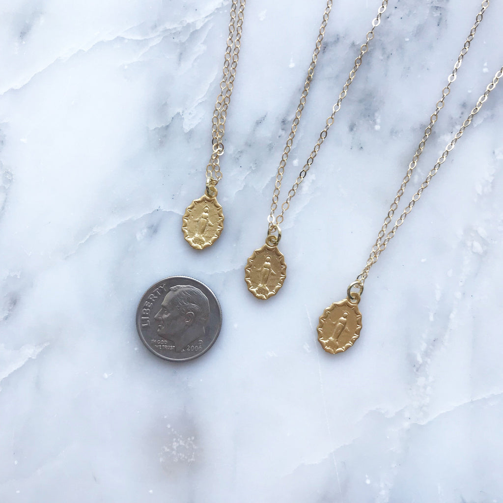 Medal pendant necklace links with oval medallions, shown with a coin for scale