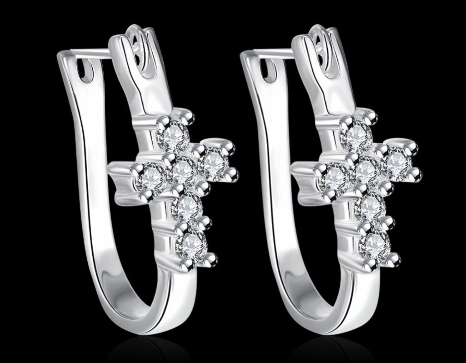 Silver-tone cross huggie hoop earrings with clear CZ cross clusters, pair view.