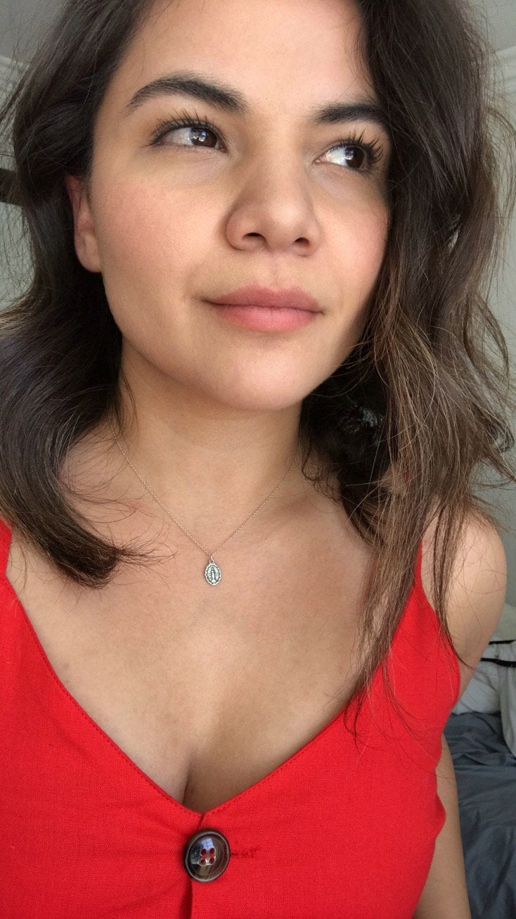 Bronze teardrop-style pendant necklace on a woman wearing a red top.