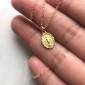 Medal pendant necklace with oval charm on a fine gold-tone chain