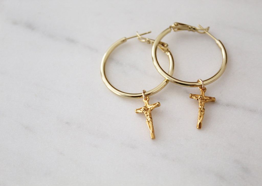 Gold-tone hoop earrings with crucifix cross charms, shown as pair