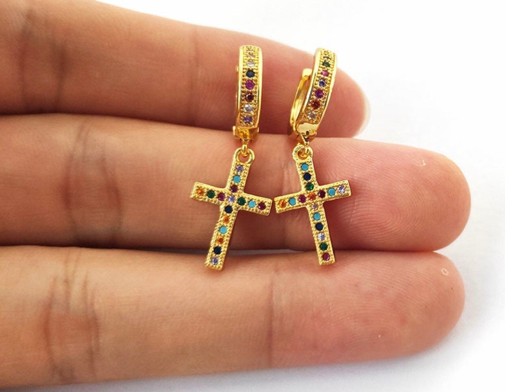 Gold hoop earrings with cross dangle, multicolor stones, shown on hand