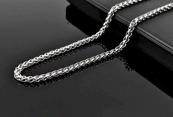 Stainless steel link chain necklace draped over black tag