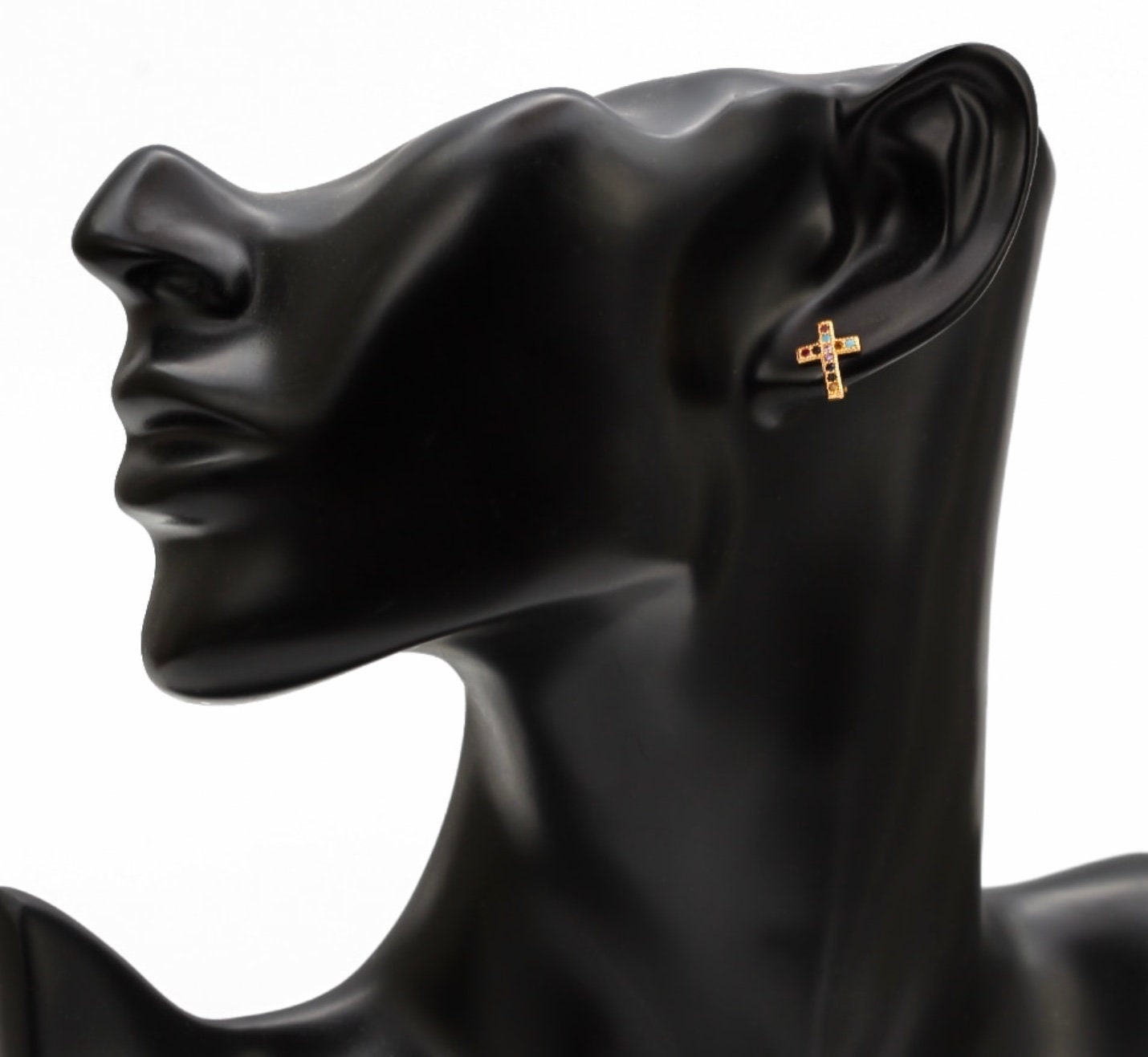 Gold cross stud earrings with multicolor zircon inlay on a black mannequin