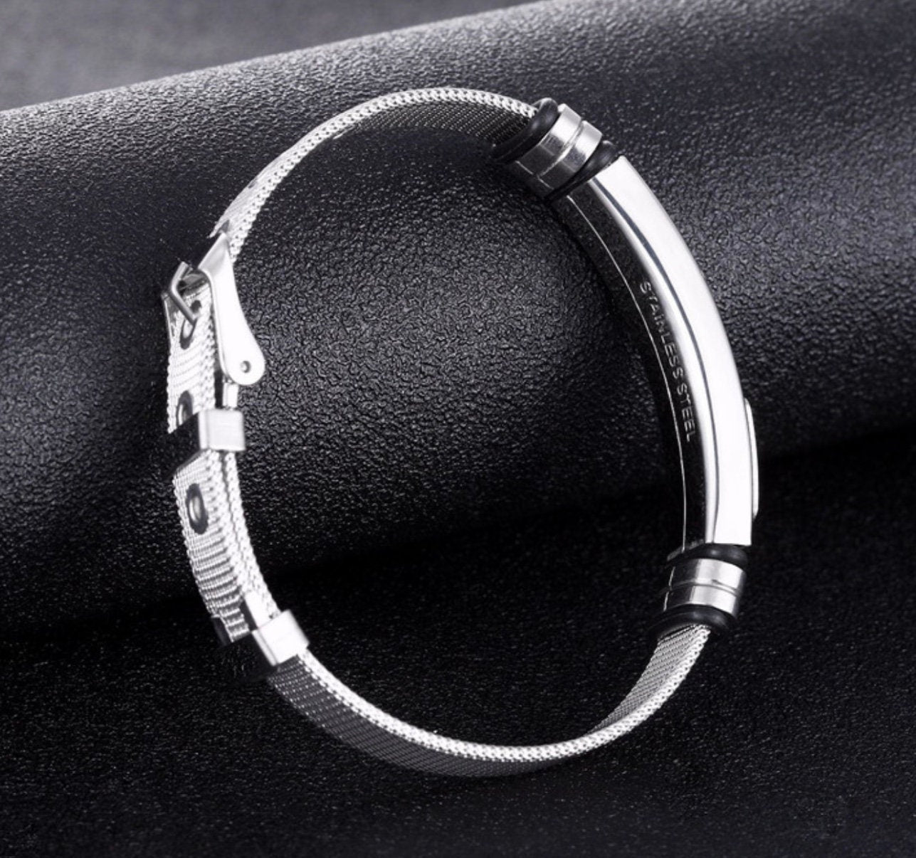 Silver mesh bracelet with black inlay accents and metal clasp on cuff frame