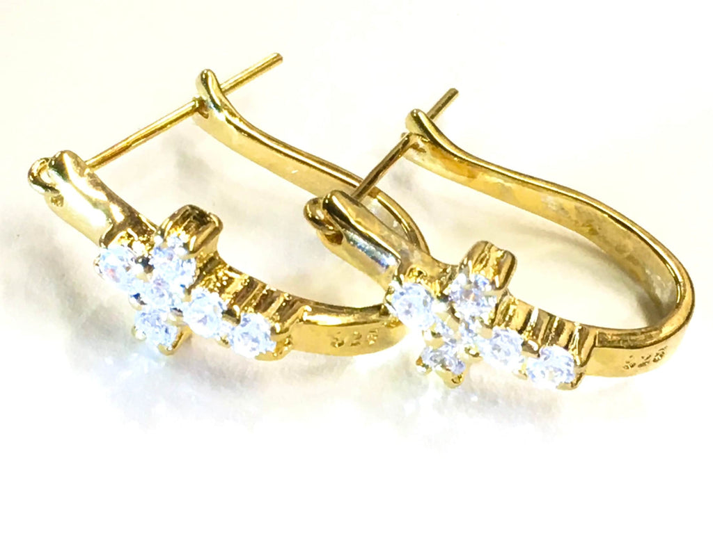 Gold-tone cross huggie earrings with clear CZ stones, flat lay on light background.