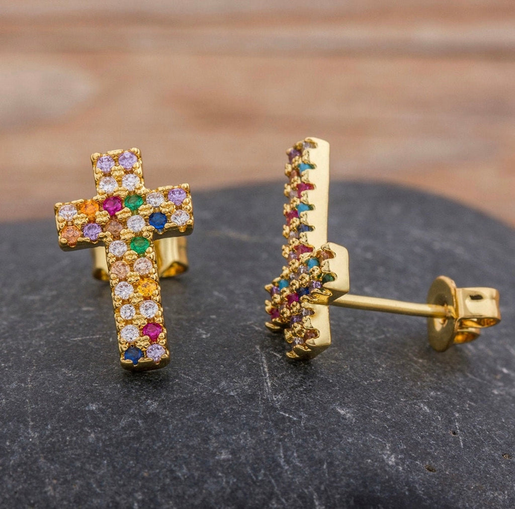 Gold-tone cross stud earrings with rainbow rhinestone inlay, close-up side view.