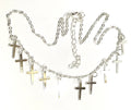 Silver-tone cross necklace and earring set with small cross charms, flat lay