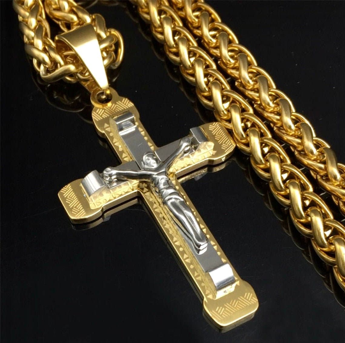 Close-up two-tone crucifix pendant on gold curb chain