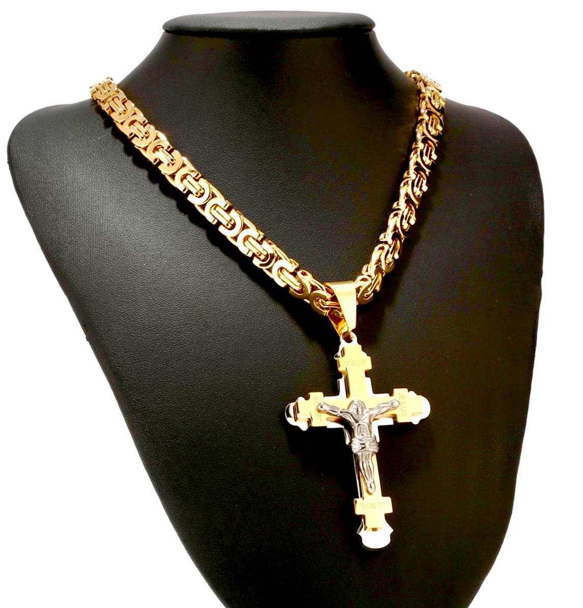 Crucifix cross pendant on gold-tone chain, worn on black necklace display