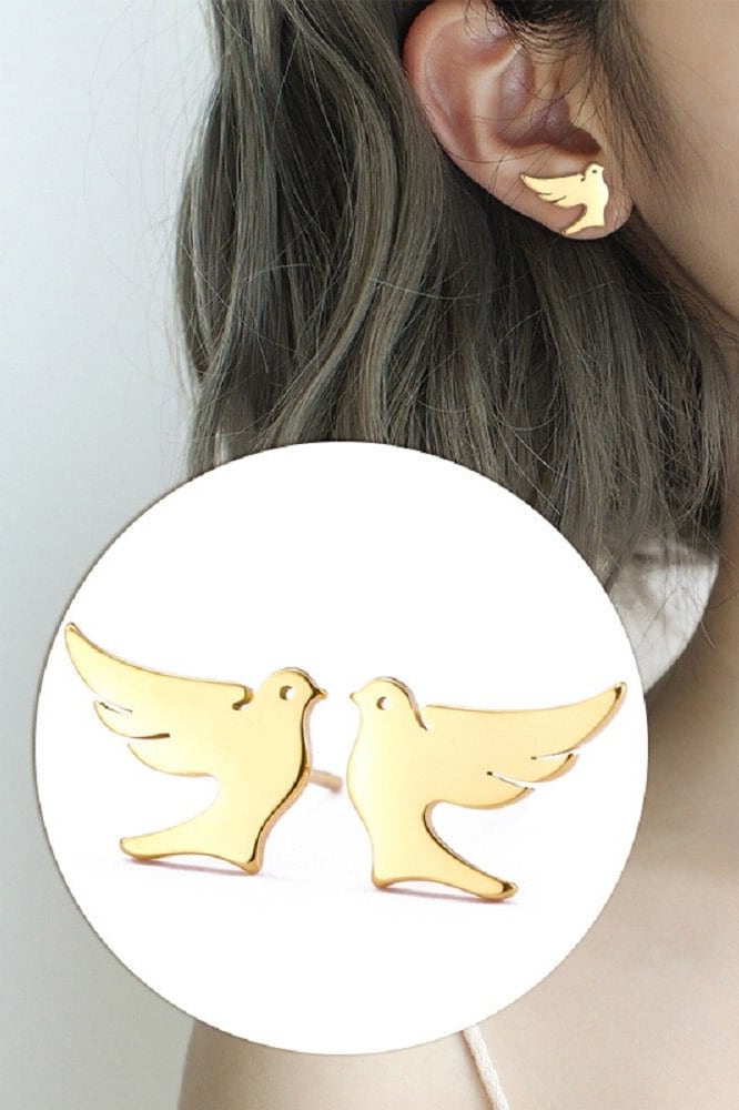 Gold dove stud earrings worn on ear