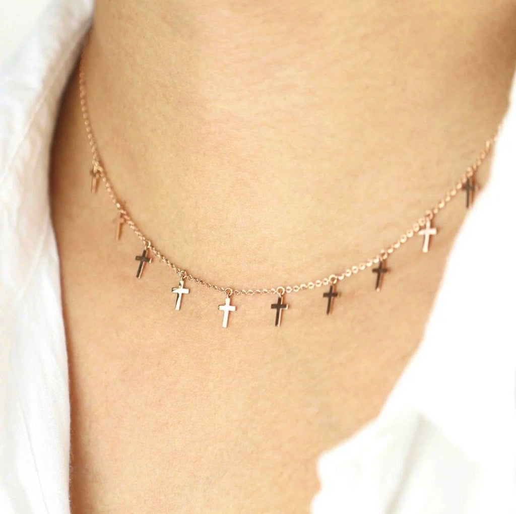 Gold-tone cross chain choker necklace with small dangling crosses, shown on neck