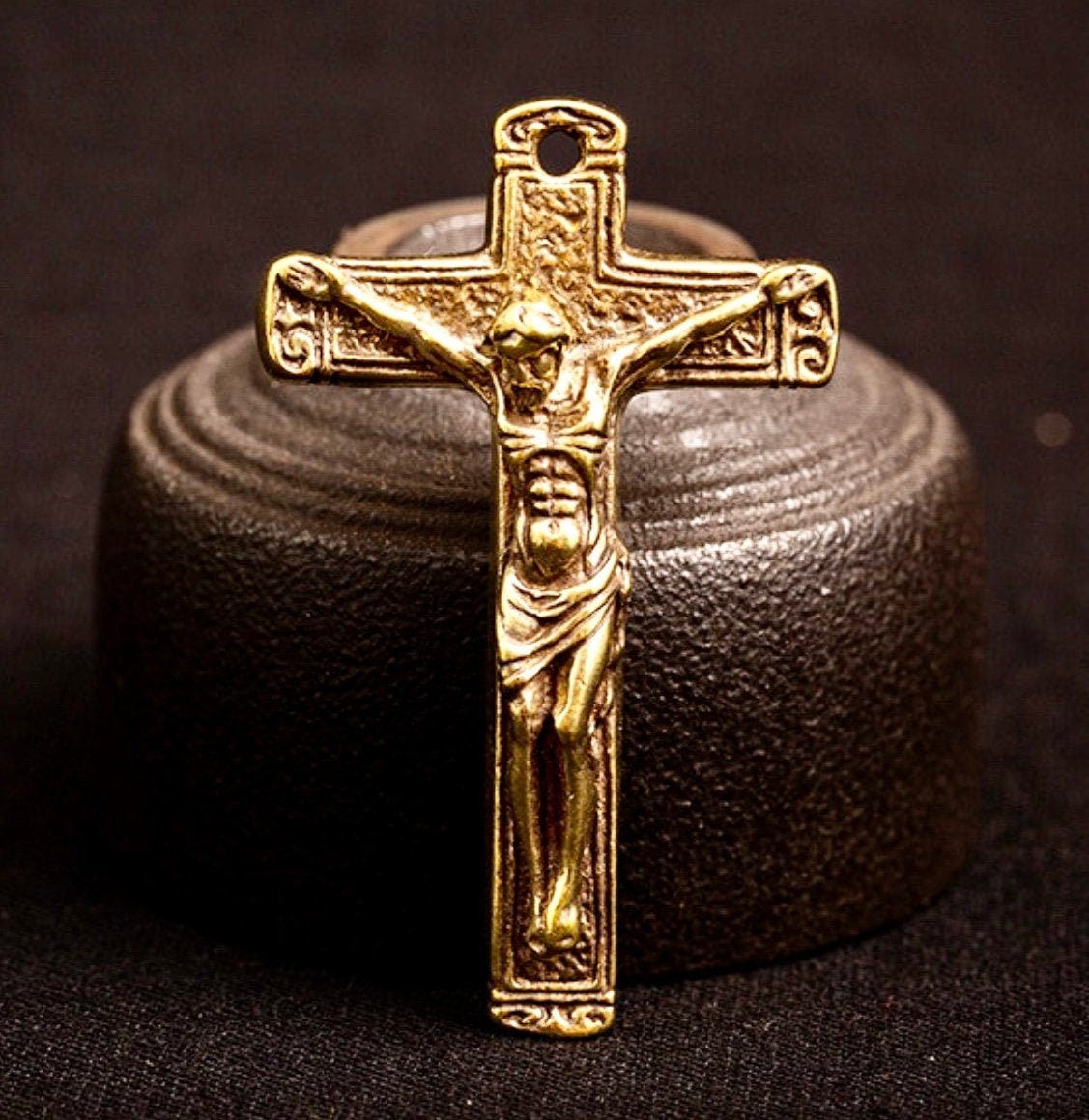 Bronze crucifix pendant, ornate detailing, with chain loop.