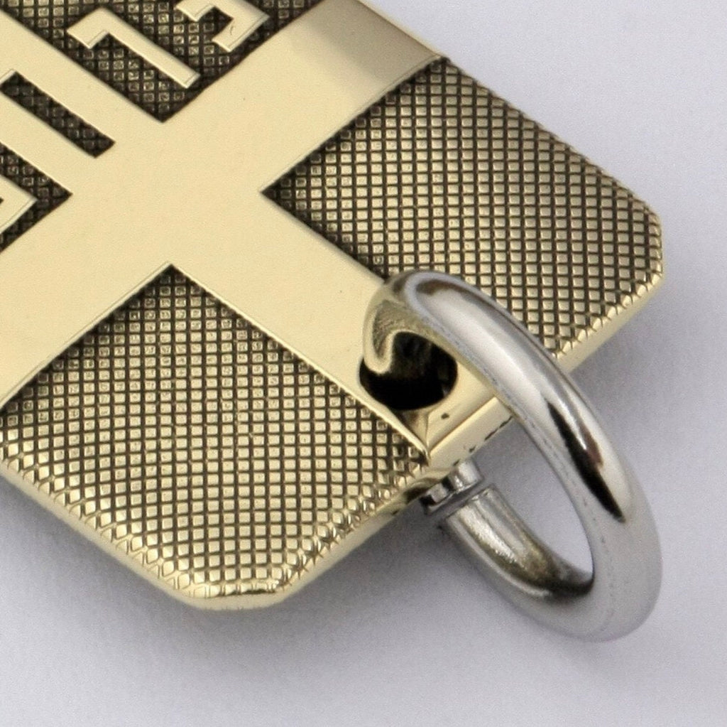 Close-up of gold-tone dog tag cross pendant bail ring and front cross engraving