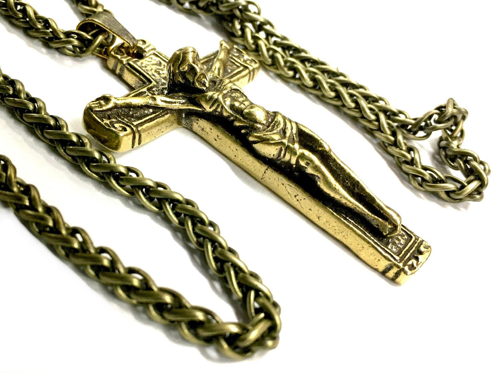 Bronze crucifix pendant on heavy chain necklace, close-up angle.