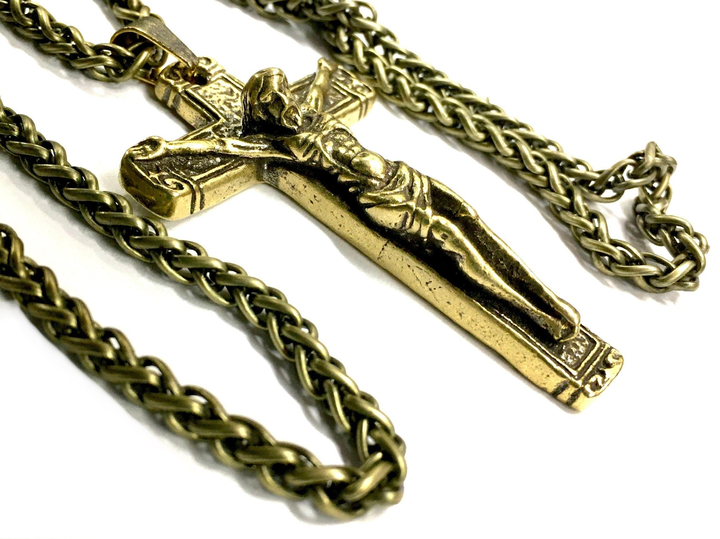 Bronze crucifix pendant on heavy chain necklace, close-up angle.