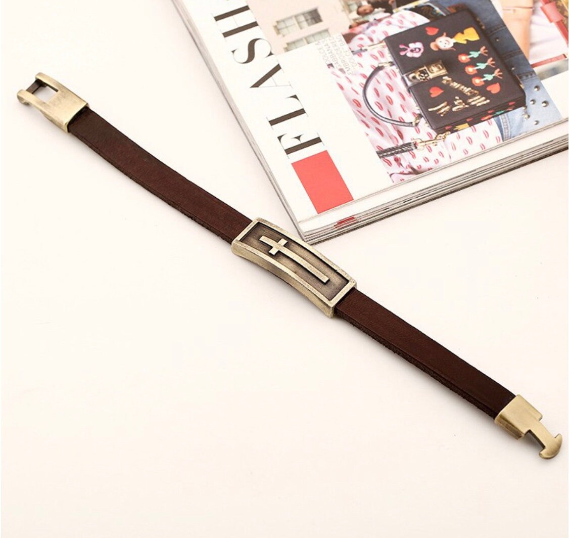 Brown leather cross bracelet with gold-tone square clasp and raised cross detail
