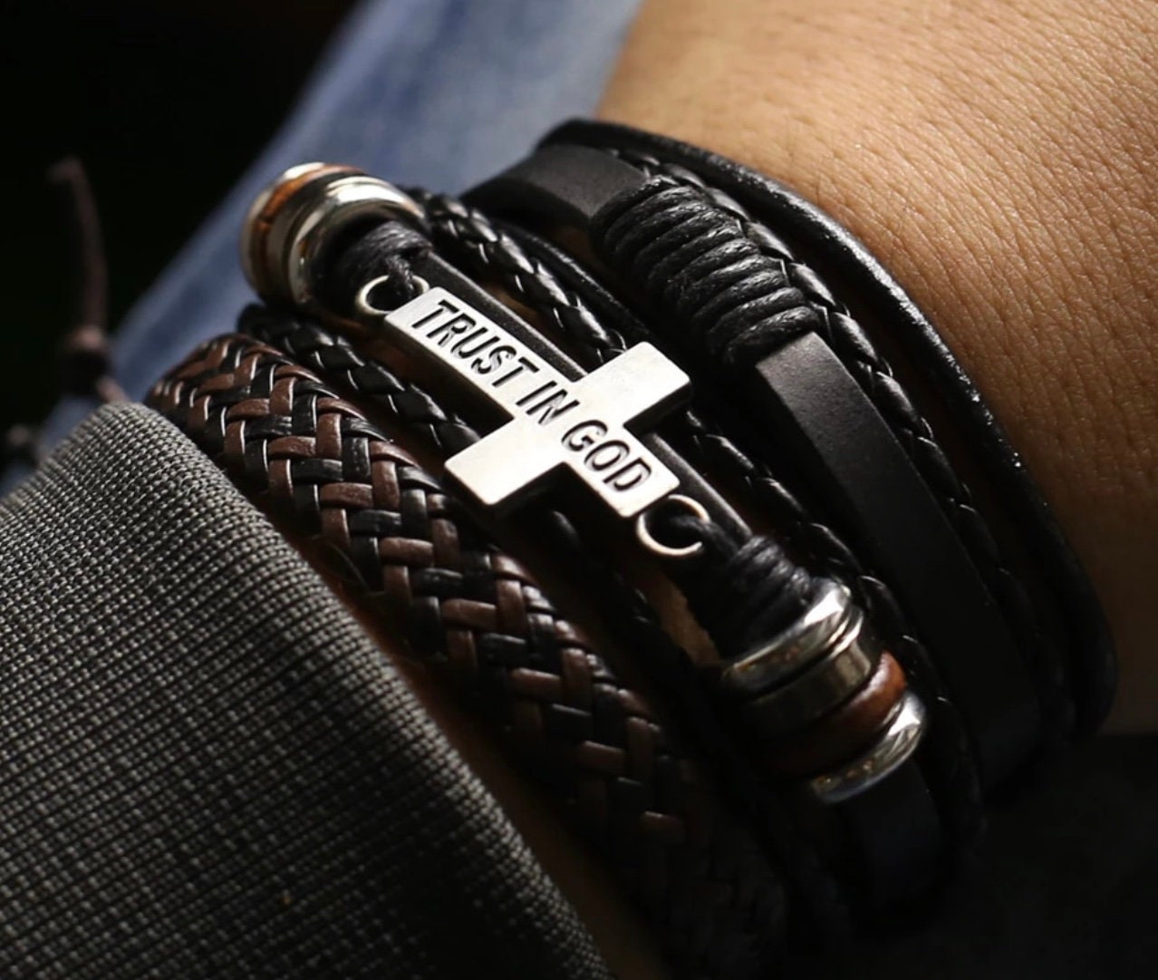 Black braided leather bracelet with metal tag engraved “TRUST IN GOD” and snap rings