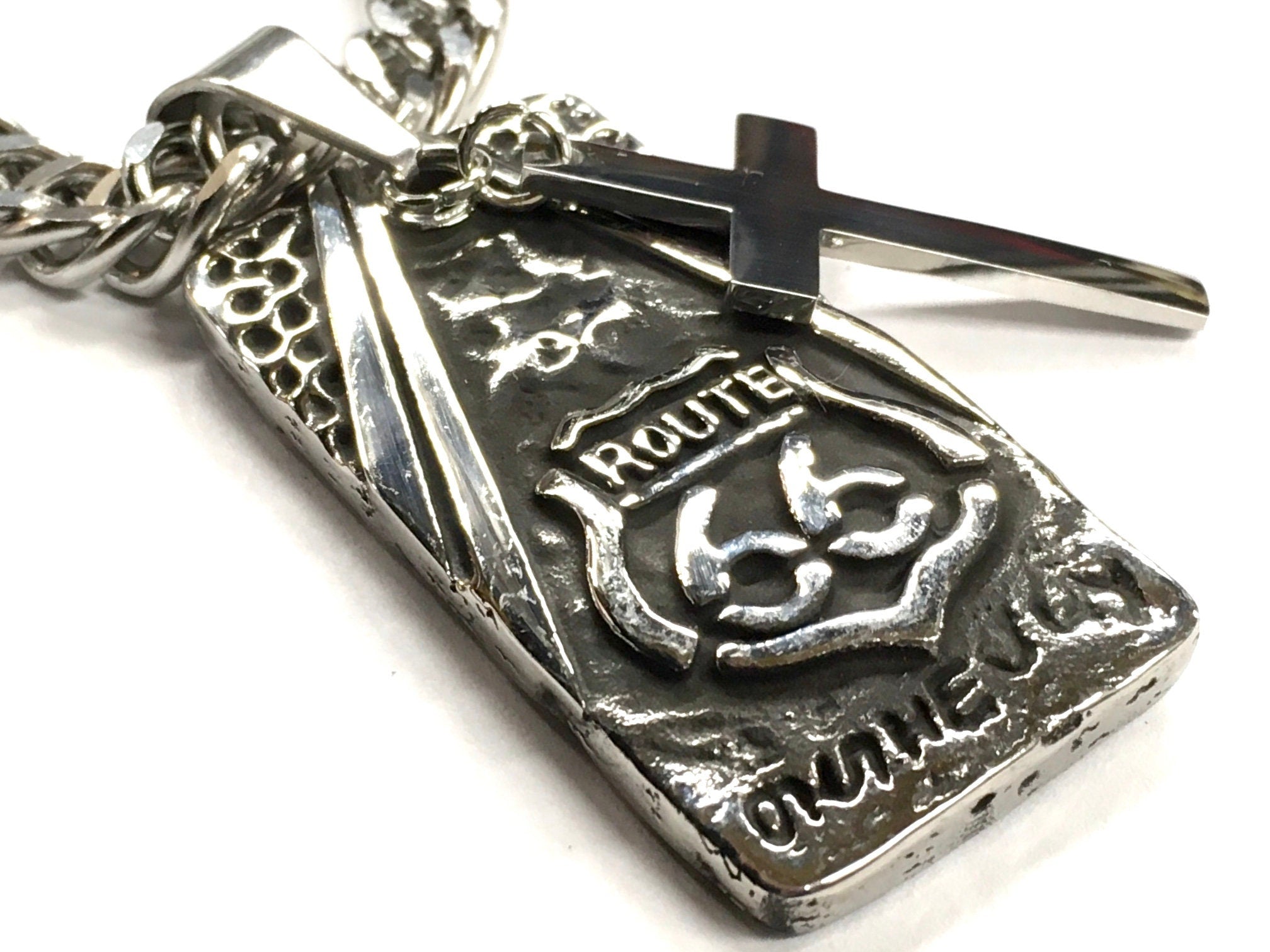 Metal dog tag pendant with cross top and Route 66 relief on curb chain