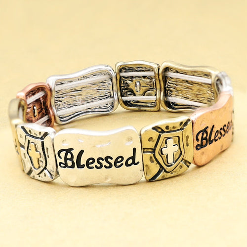 Gold-tone stretch bracelet cuff with three linked panels, cross emblem, and “Blessed”
