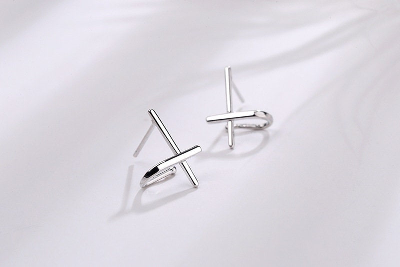 Sterling silver cross huggie stud earrings, angled view with post backs