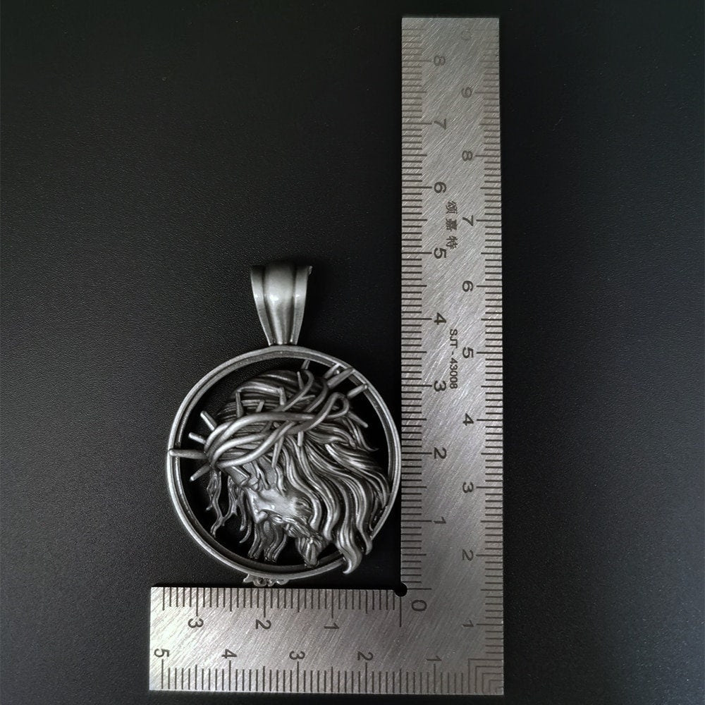 Religious Jesus medallion pendant necklace with size shown by ruler, antiqued finish.