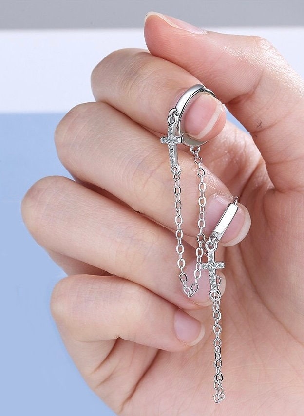 Sterling silver cross chain drop earrings shown on hand; hoop cuff with CZ
