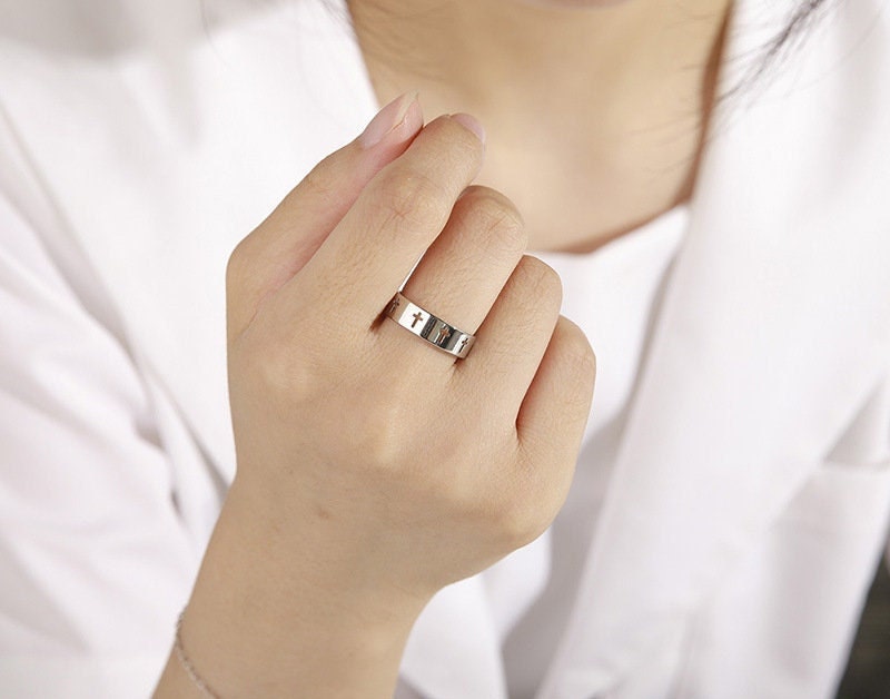 Stainless steel slender band ring with multiple cross inlays, shown on a finger